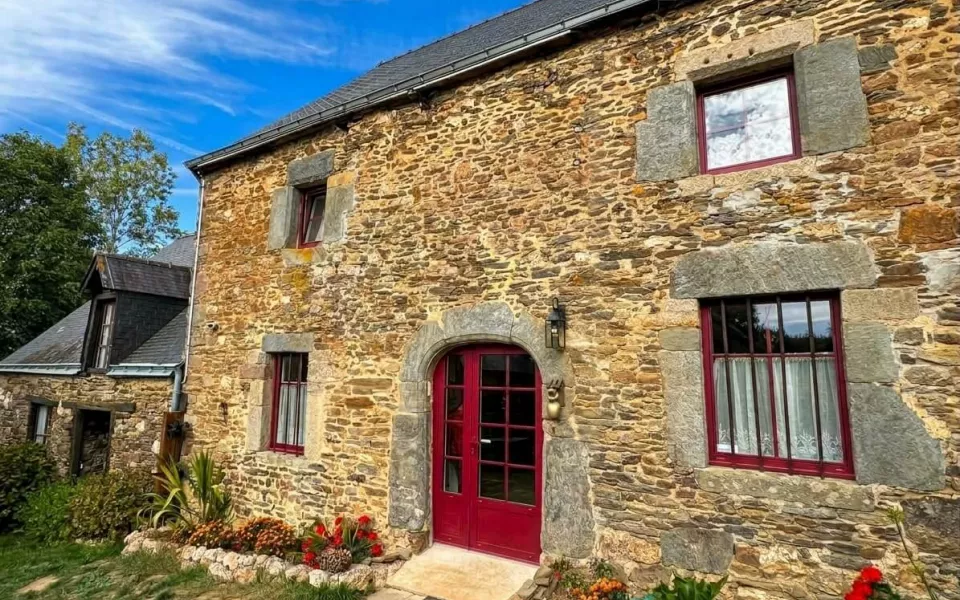 maison en pierre avec une porte rouge