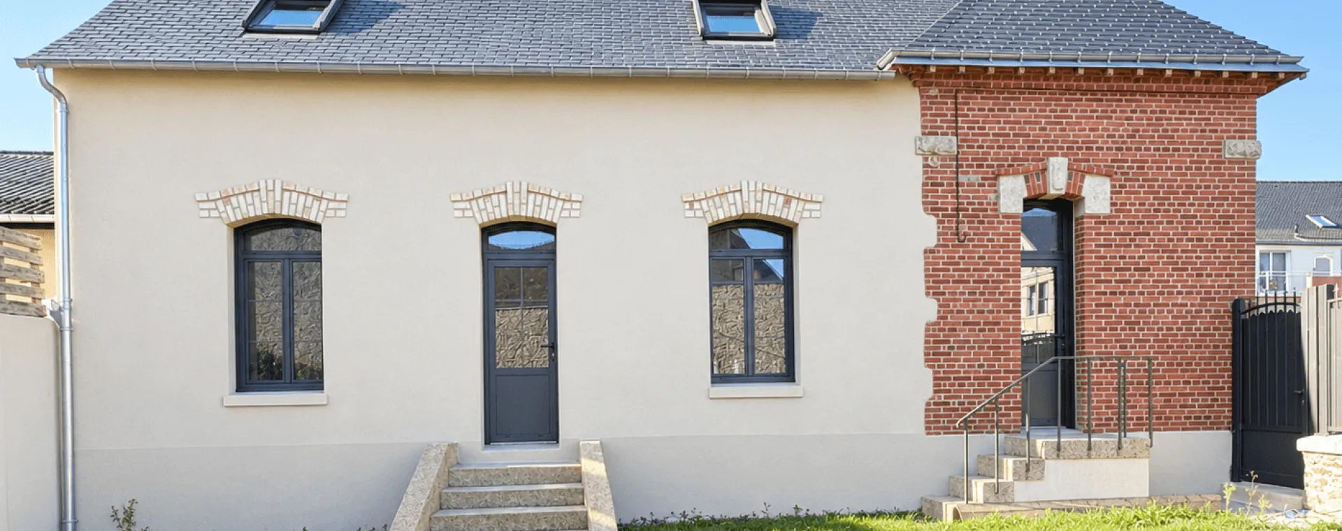 maison résidentielle en Bretagne avec façade blanche et section de briques rouges