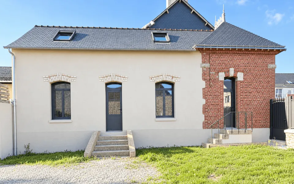 maison résidentielle en Bretagne avec façade blanche et section de briques rouges