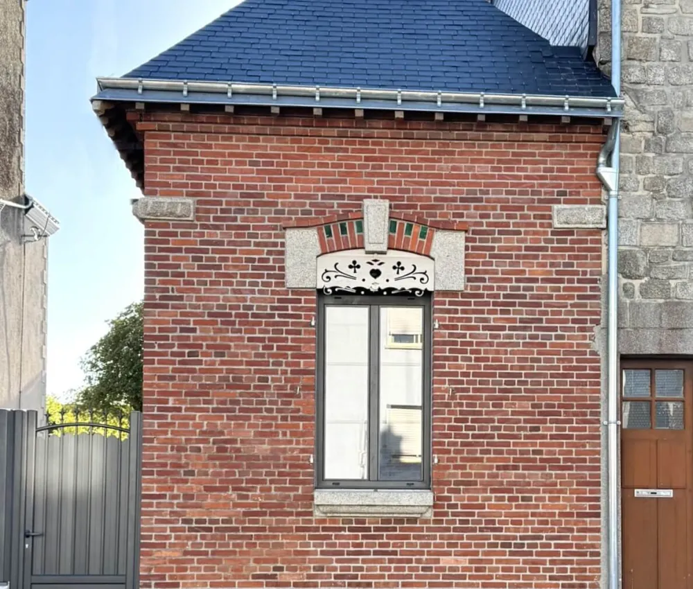 maison en brique avec toit à pignon et fenêtre