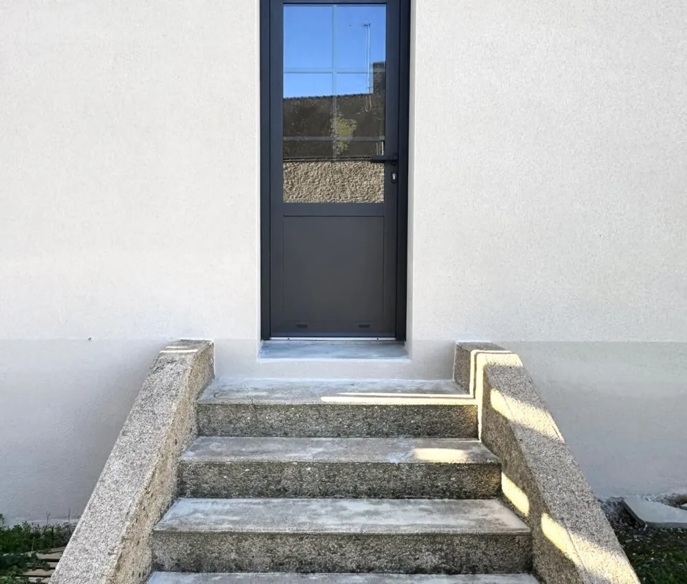 porte d'entrée en béton avec un arc de briques