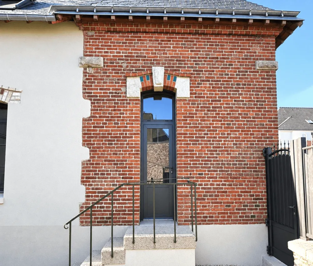 maison en brique et blanc avec entrée en bois